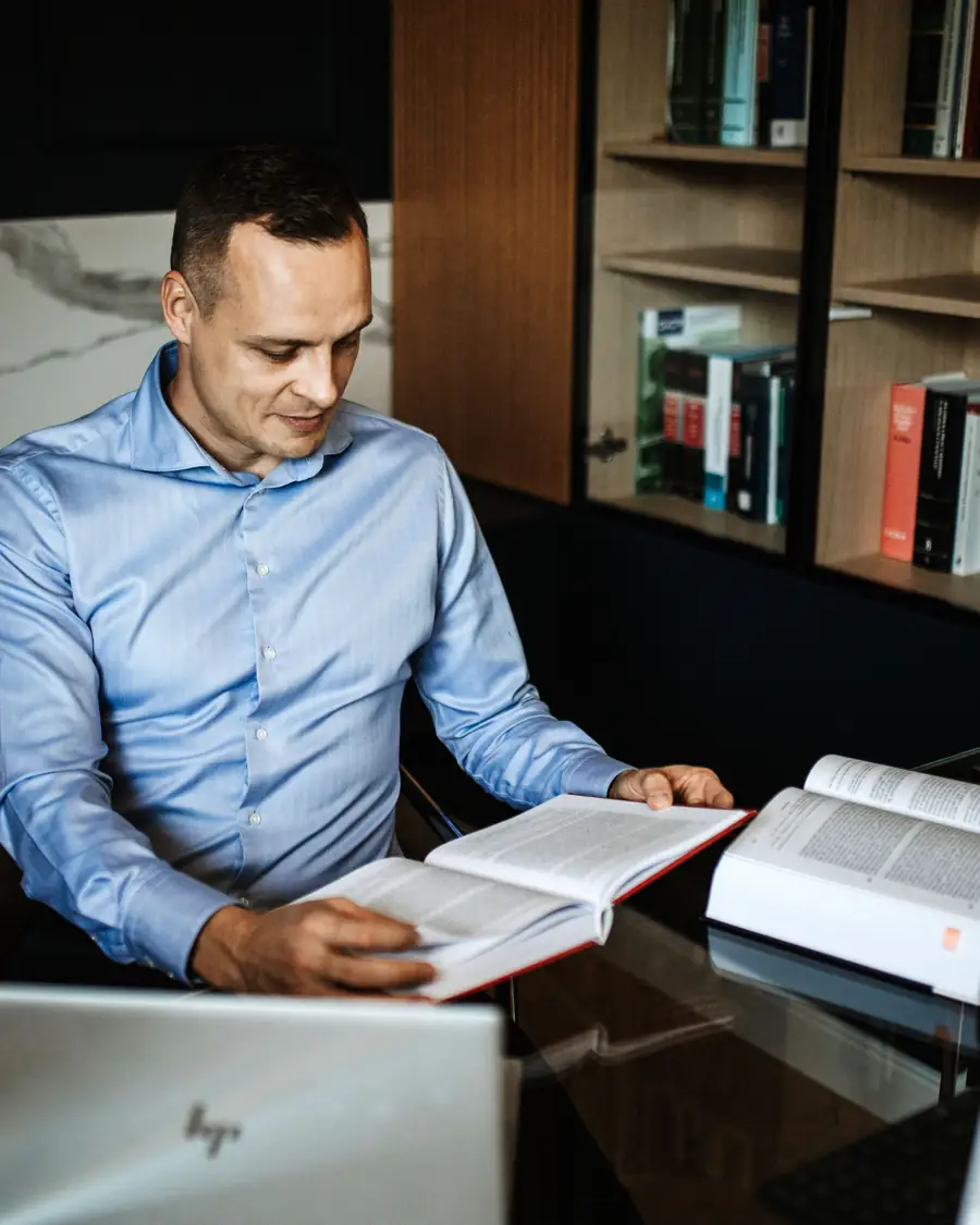 Dr. Artur Barczewski liest Unterlagen am Schreibtisch